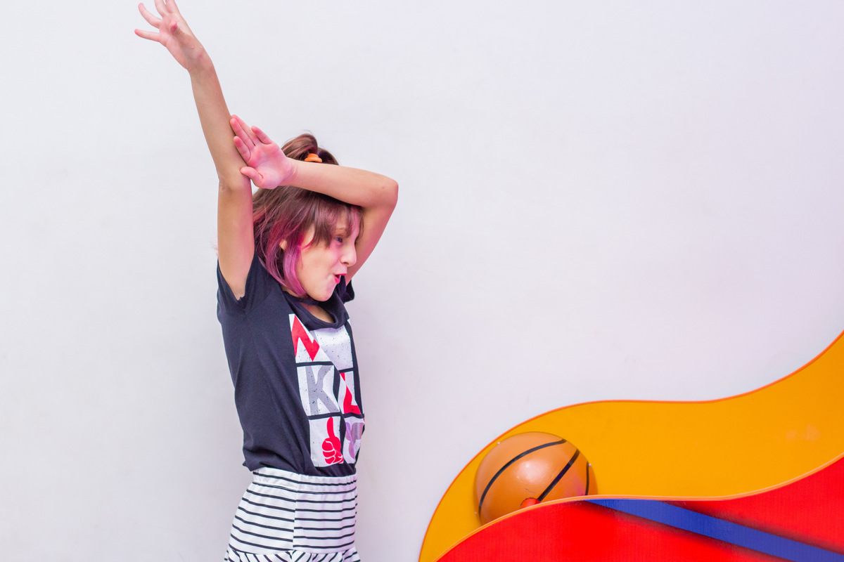 menina de cabelo rosa brincando de basquete