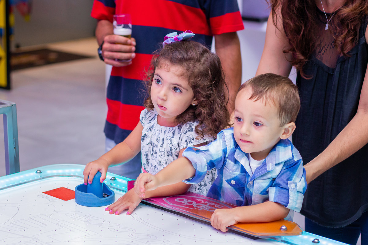 nenês brincando de air hockey em aniversário