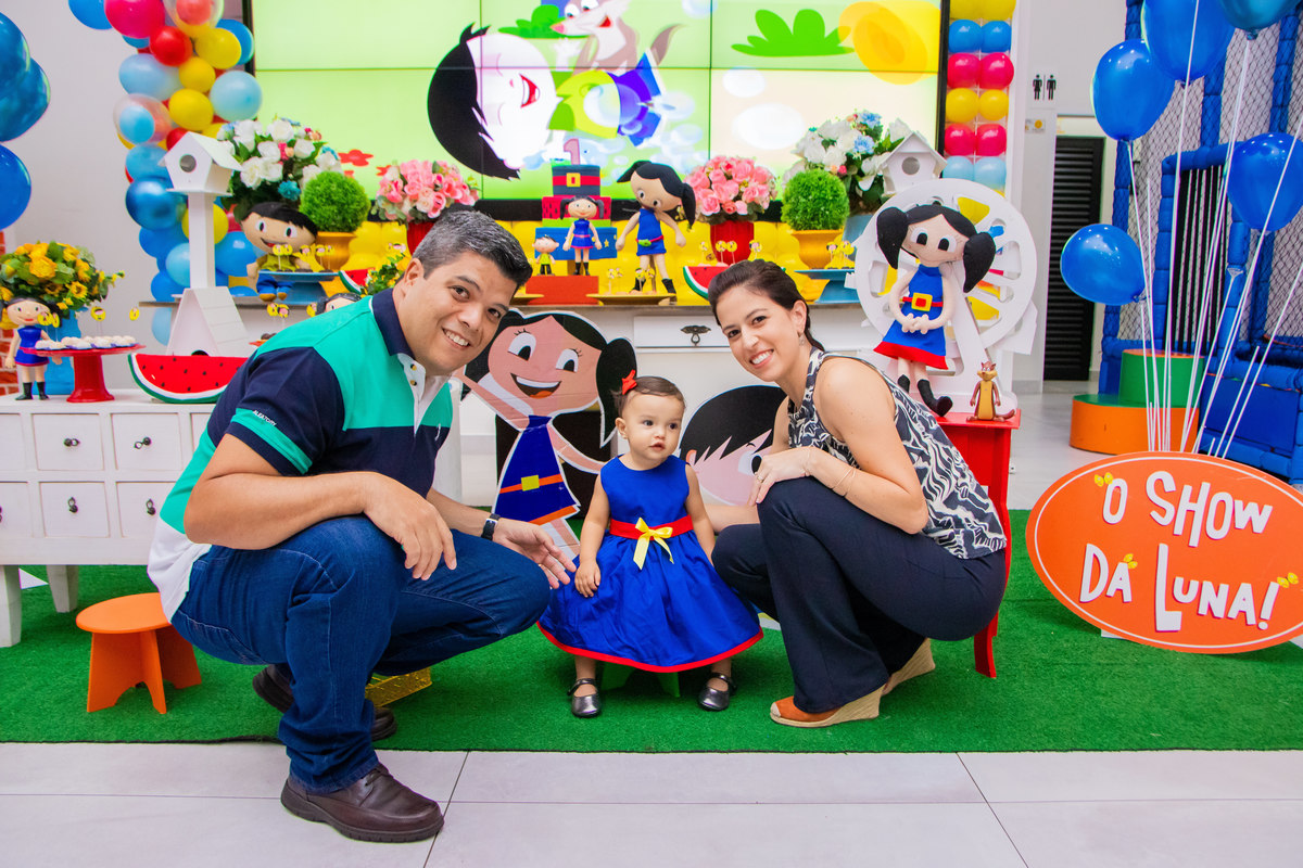 Mãe, pai e aniversariante na mesa do bolo