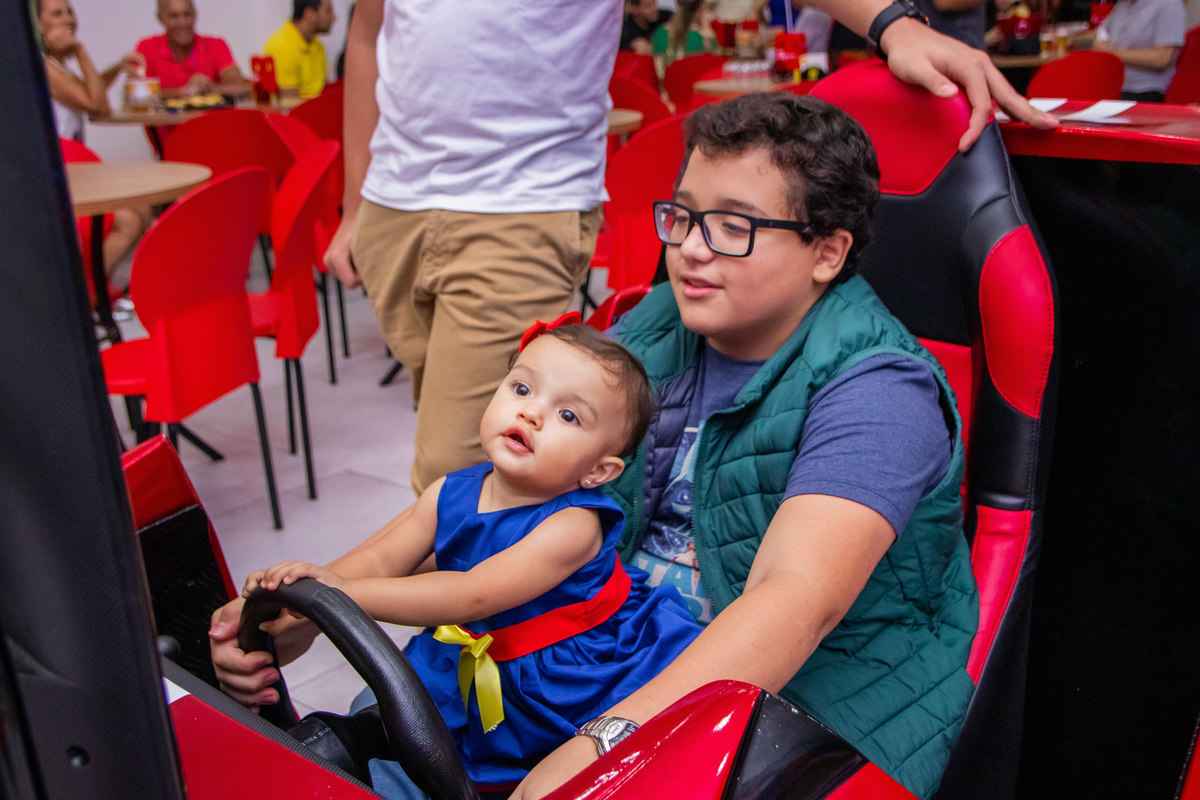 aniversariante e primo brincando no video game de dirigir