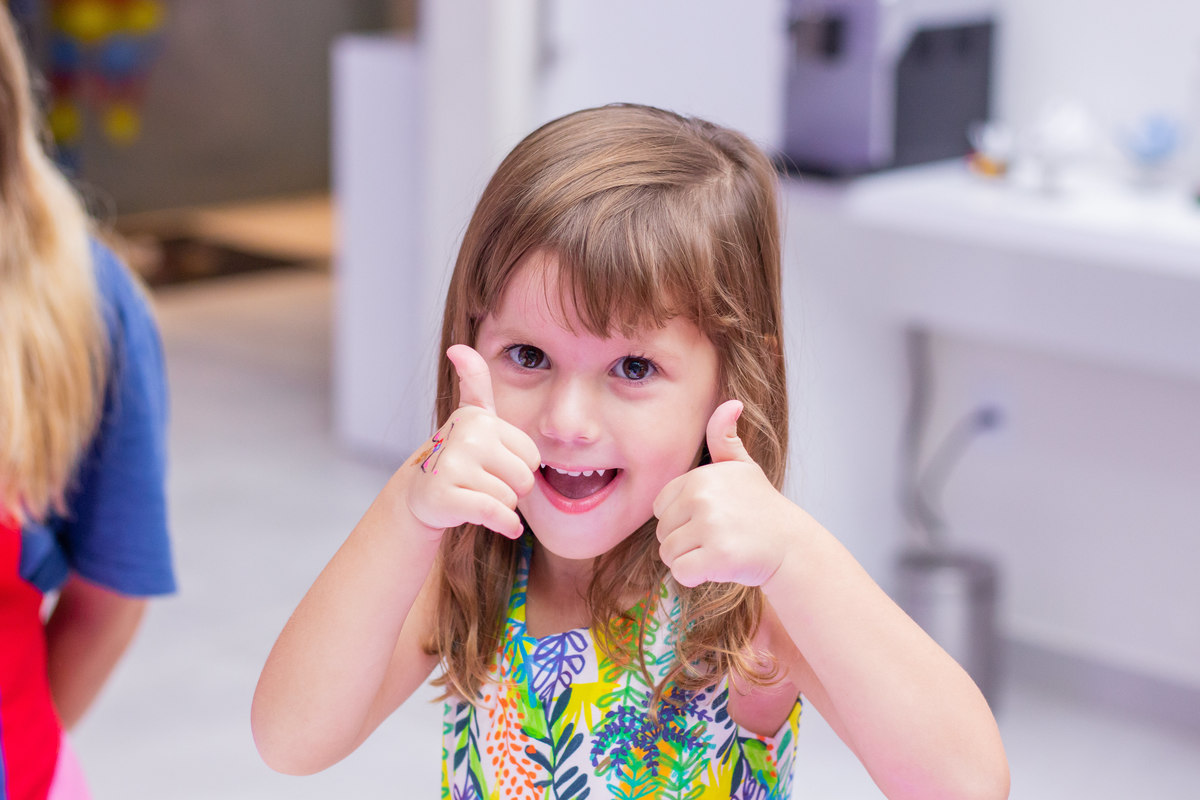 menina fazendo jóinha em aniversário