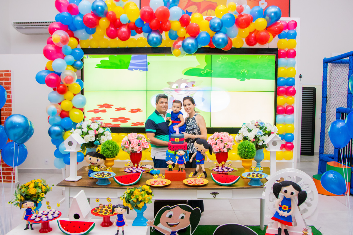 Foto com os pais na mesa do bolo