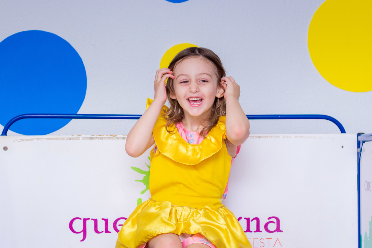 Menina fantasiada de A bela e a Fera brincando no tombo lega