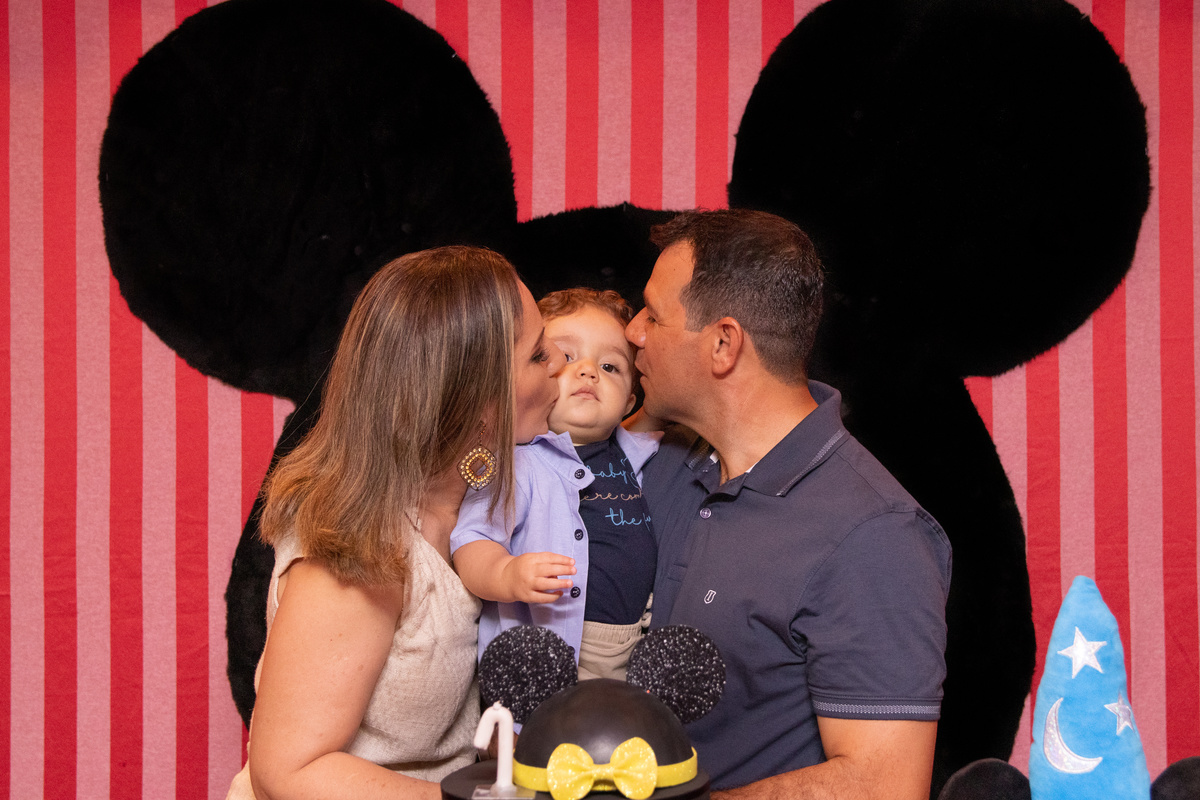 Pais beijando o filho em aniversário