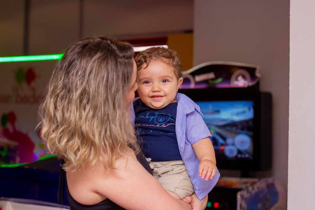 Aniversariante sorrindo no colo da tia