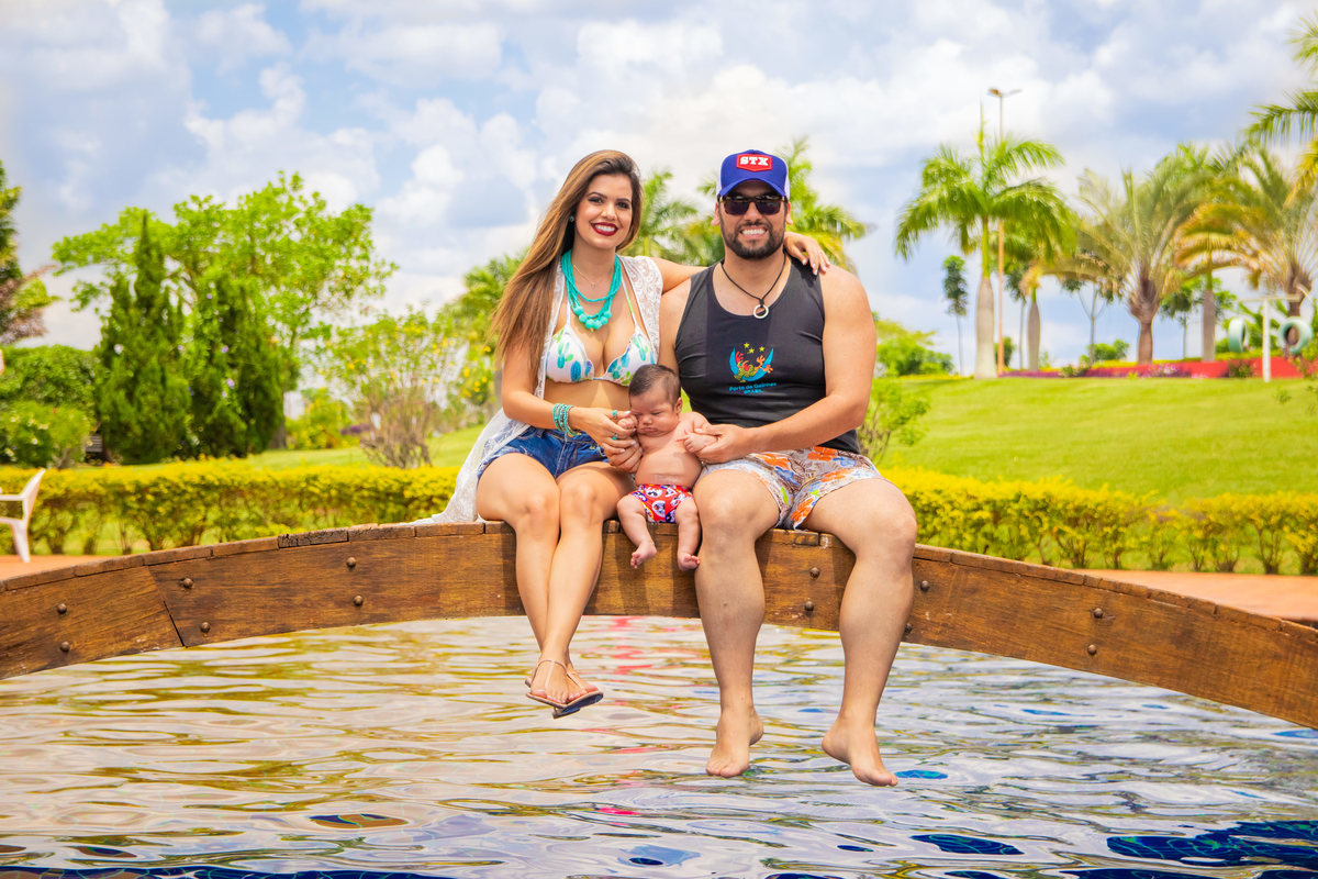 Mãe, pai e filho na beira da piscina
