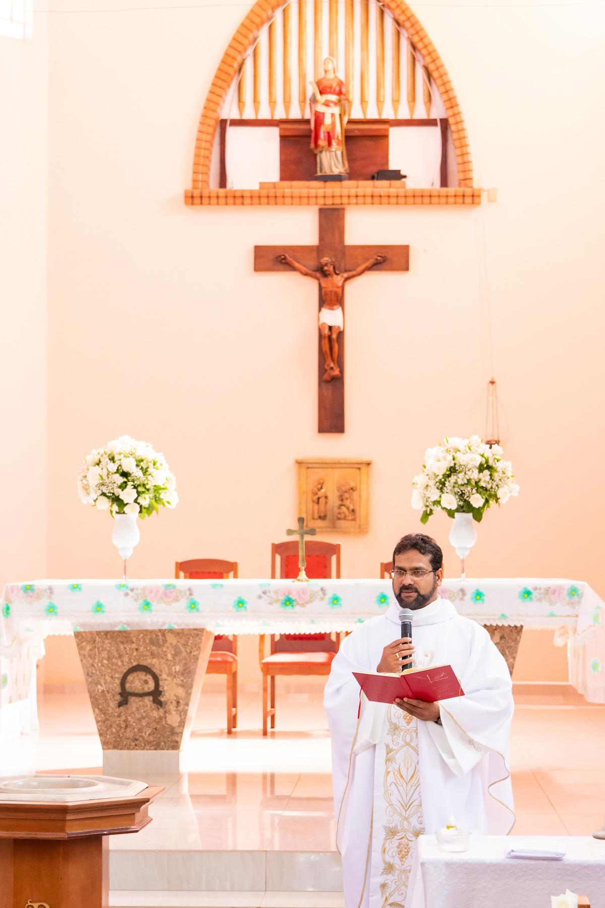 Padre lendo a palavra no dia do batismo