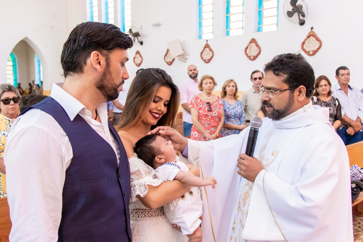 Pais e filho recebendo a benção do batismo