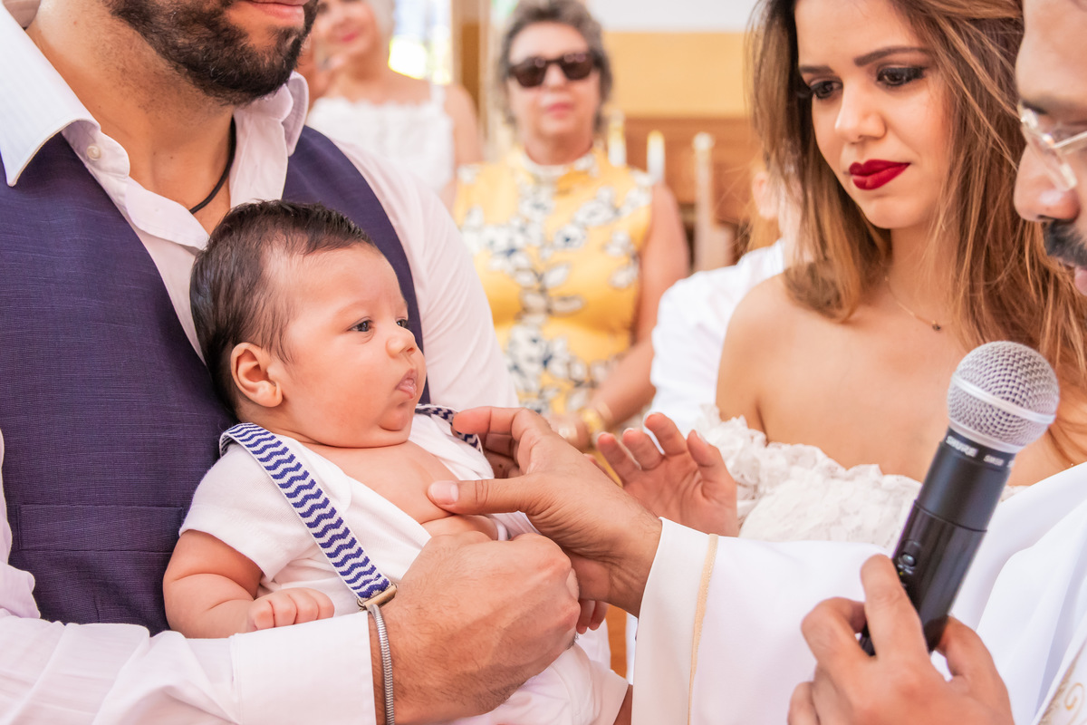 Nenê recebendo a unção do padre em seu batismo