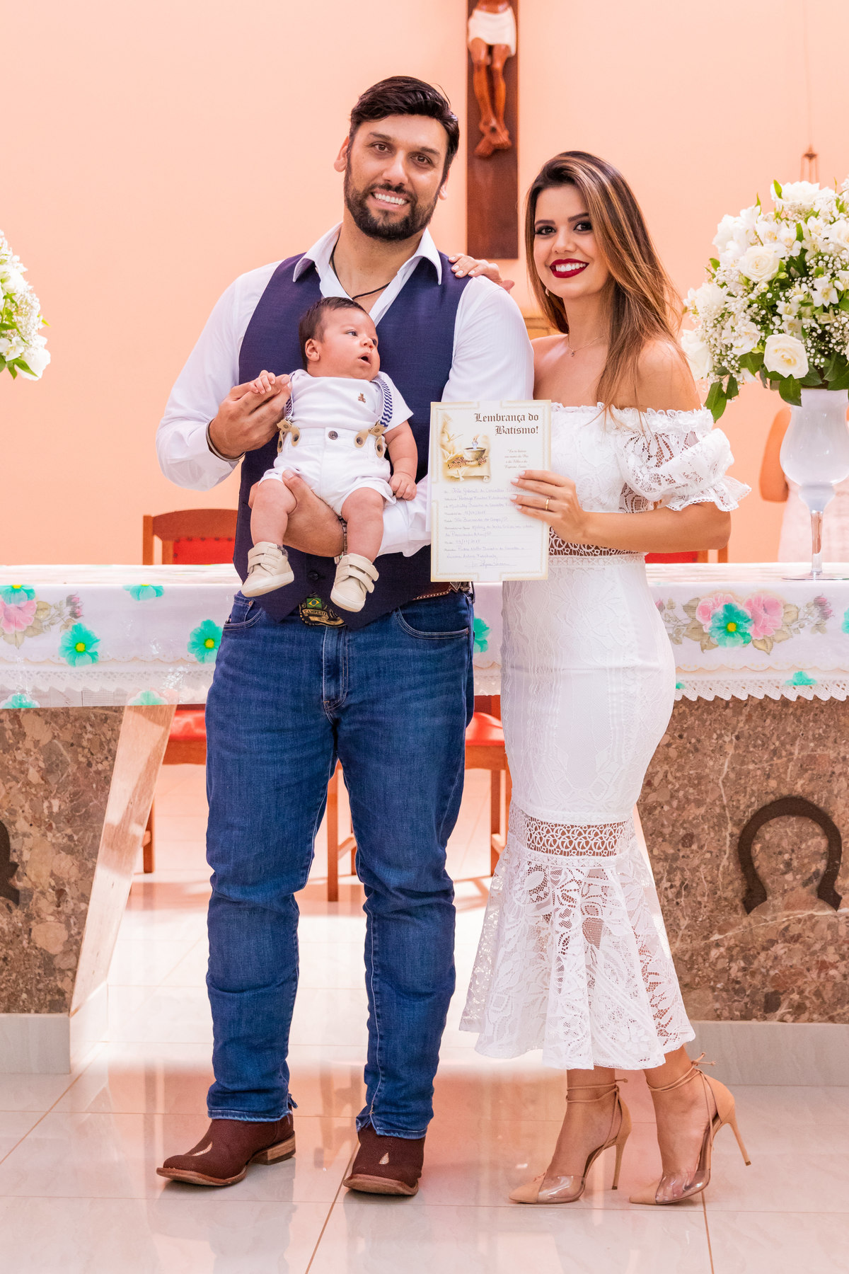 Pais e filho com o certificado de Batismo
