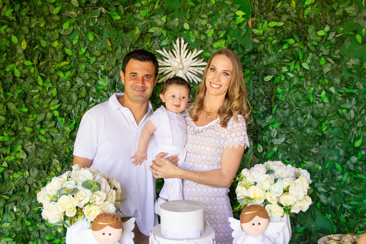 Pais e filho na mesa do bolo de batizado