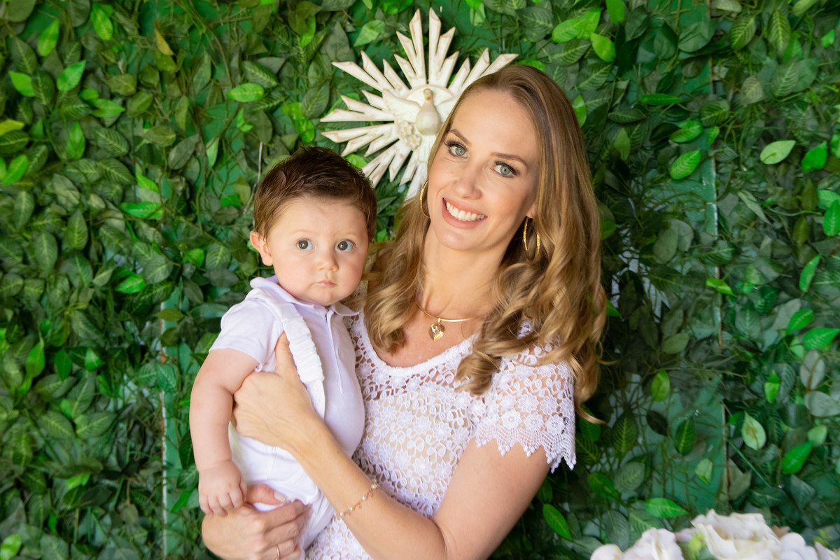 Mãe e filho na mesa de decoração do batizado