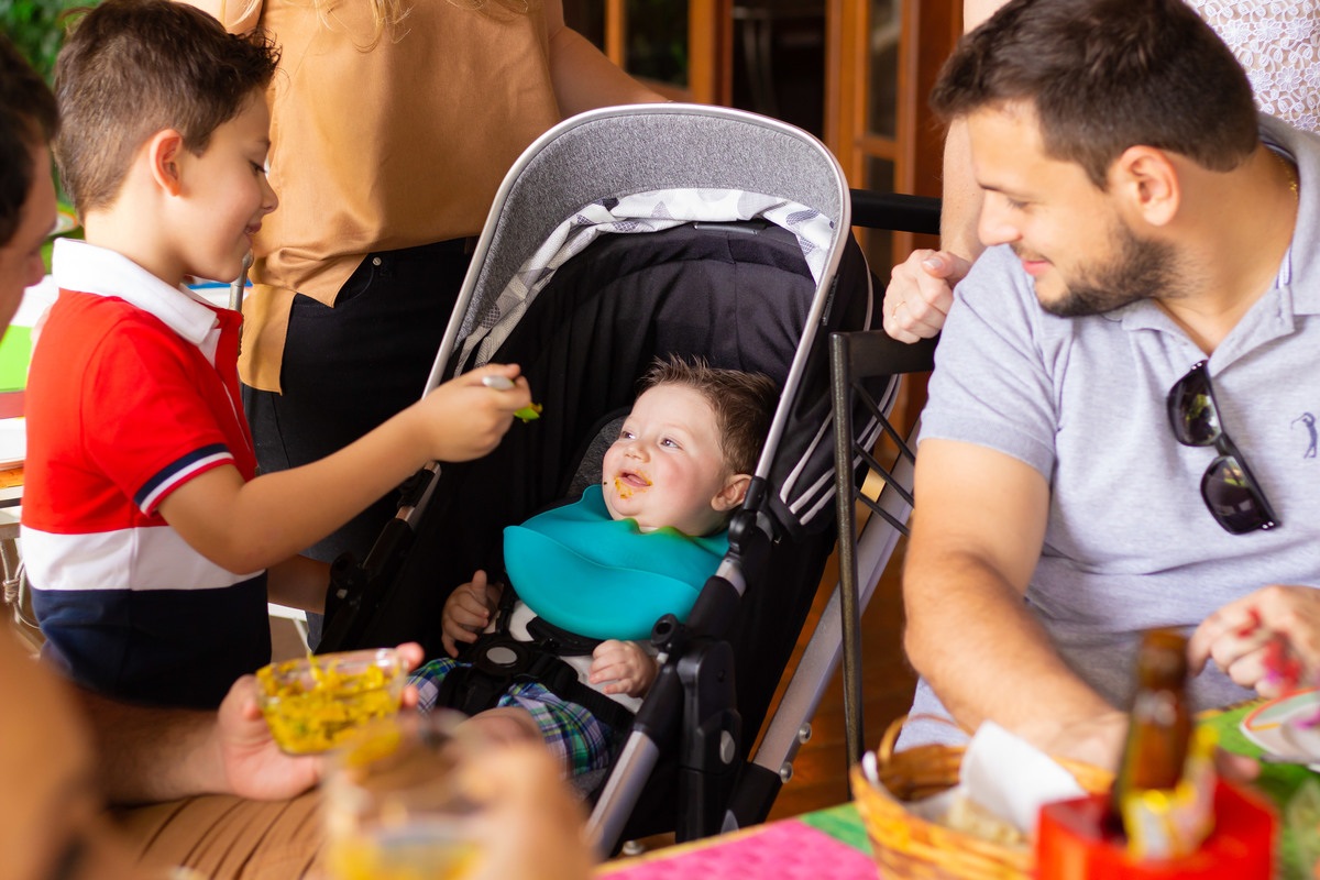 Criança dando papinha para nenê