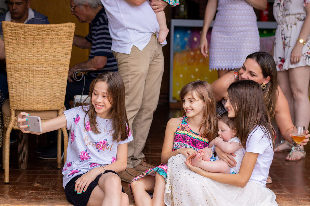 Primos tirando selfie em almoço de batizado