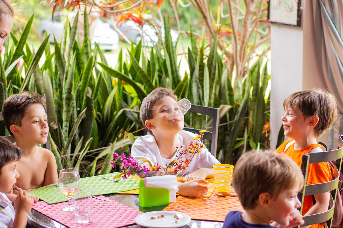 Meninos brincando com copo e fazendo careta em almoço