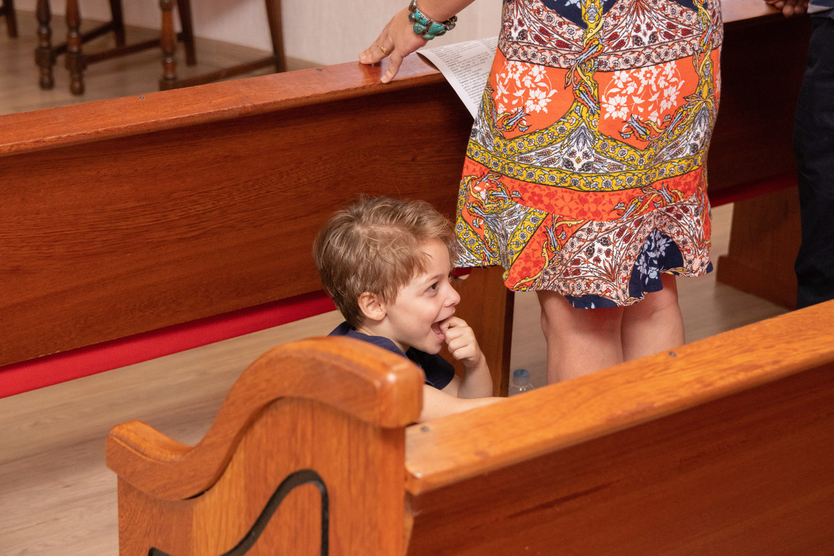 menino sorrindo em missa de batizado