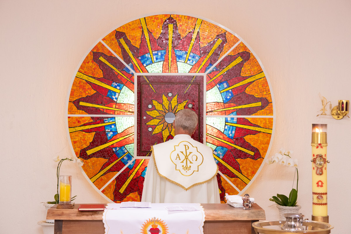 Padre iniciando a missa de batismo