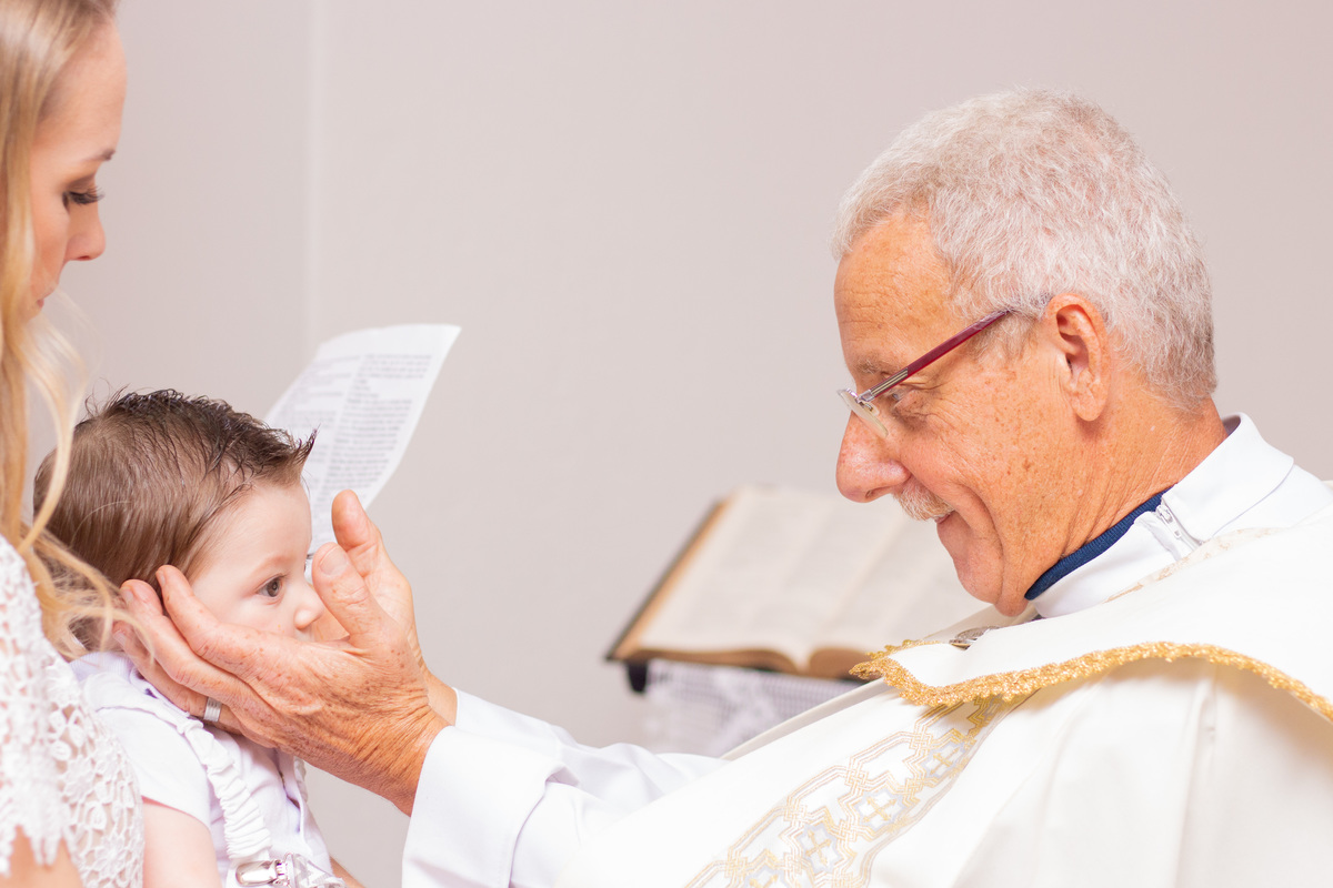 Padre dando a benção no batismo