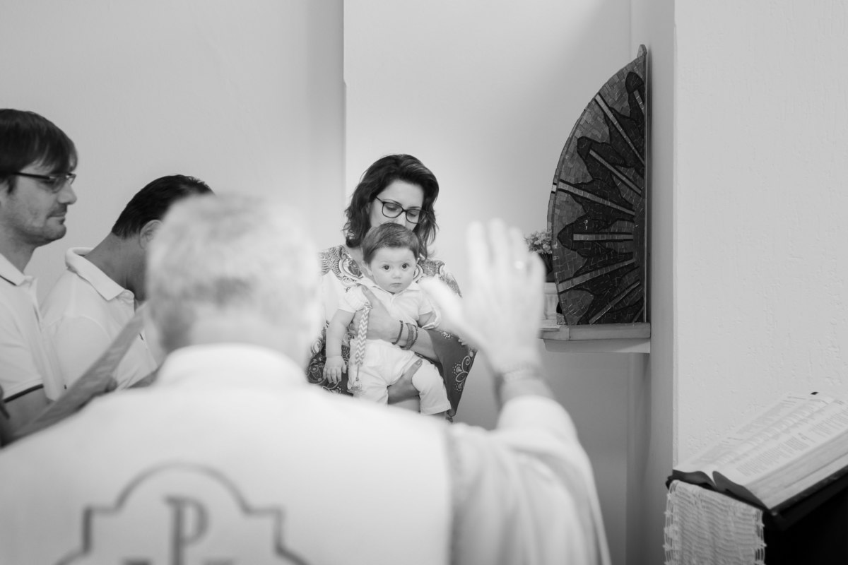 Padre rezando para nenê em seu batismo