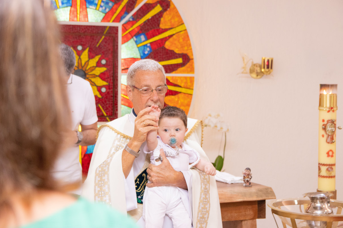 Padre abençoando o nenê em seu batismo