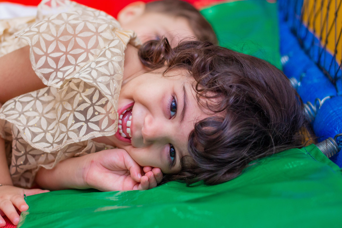 Buffet Pipoca Bauru, aniversariante deitada e sorrindo no pula pula