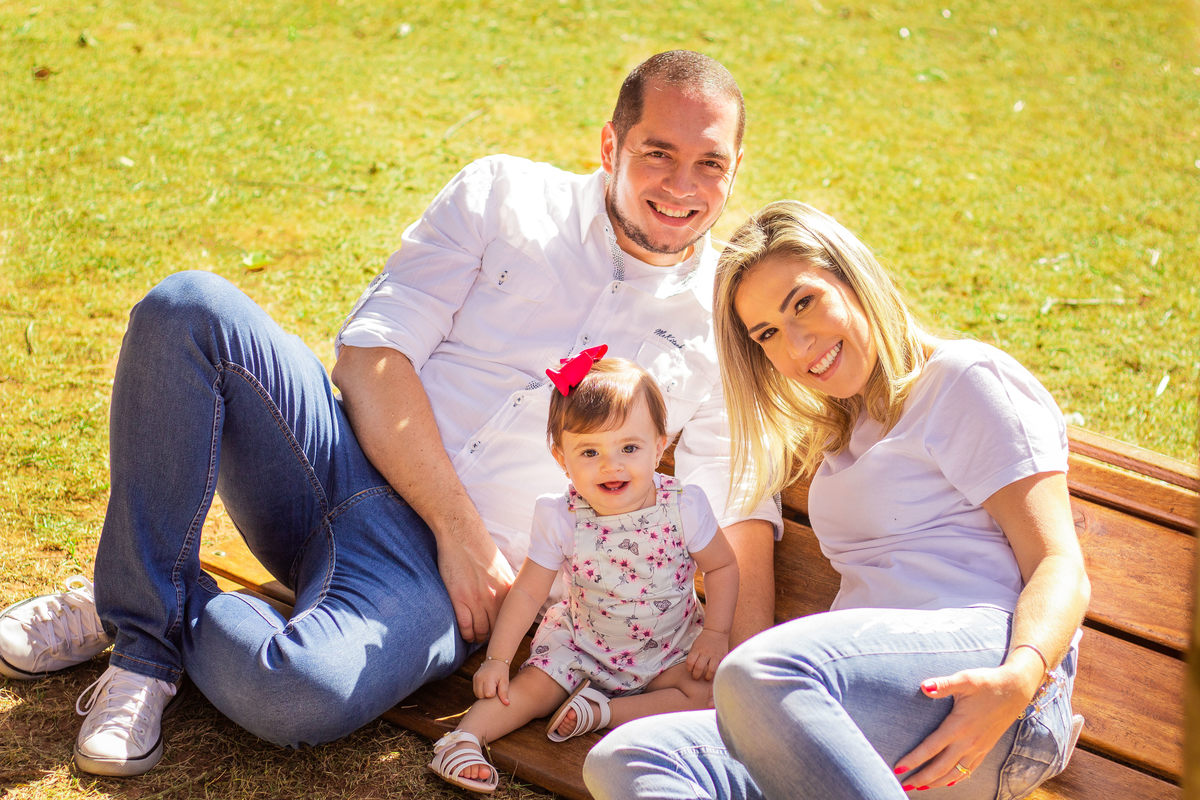 jardim botânico de bauru, ensaio externo, ensaio em família externo, pais e filha brincando e sorrindo, família sentada no banco
