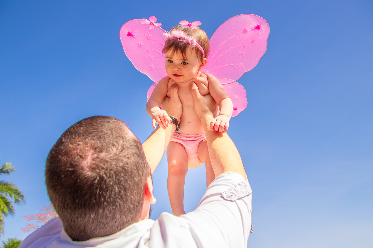 jardim botânico de bauru, ensaio externo, ensaio em família externo, pai brincando com filha de aviãozinho, bebe brincando de voar, bebe fantasiada de fadinha