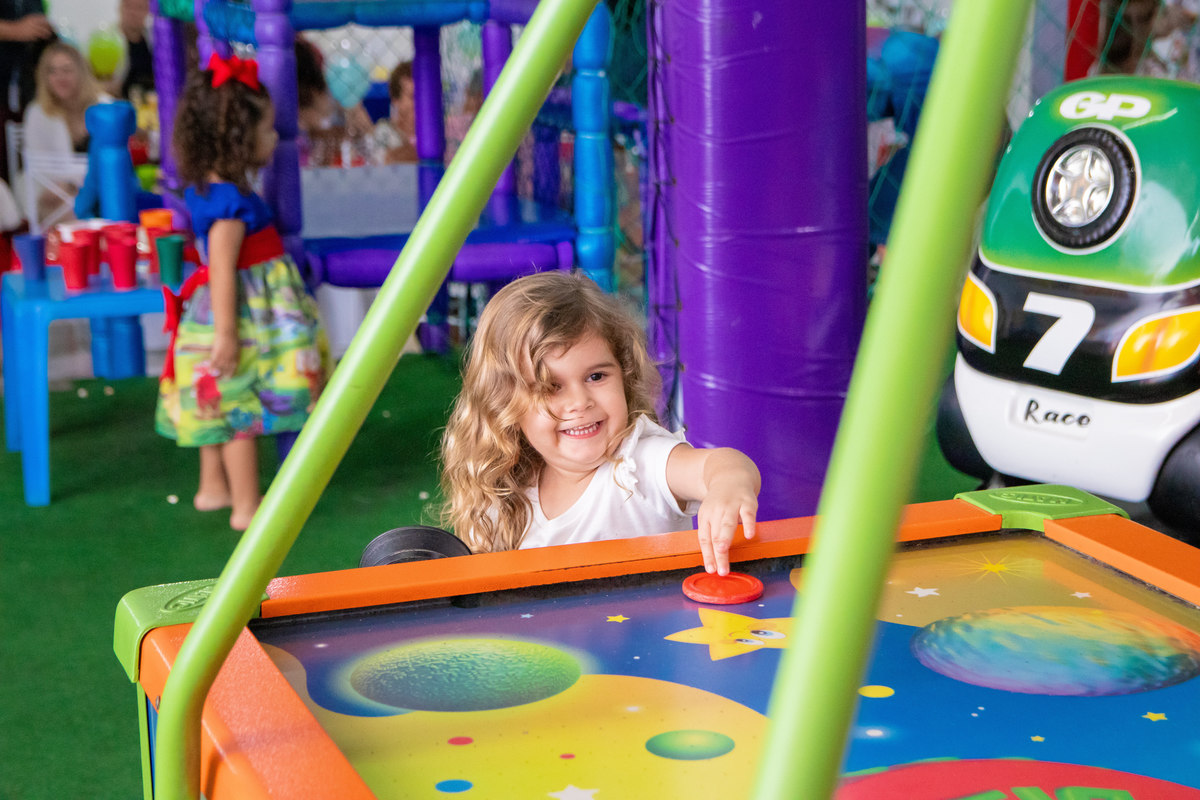 buffet biscoito bauru, buffet infantil bauru, aniversário infantil bauru, menina brincando e rindo no air hockey