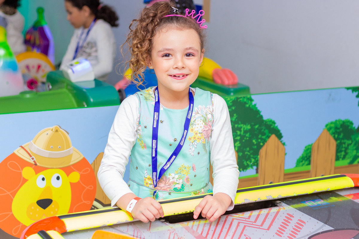 aniversário bauru shopping, decoração fini, decoração arco-iris, criança sorrindo e brincando no air hockey