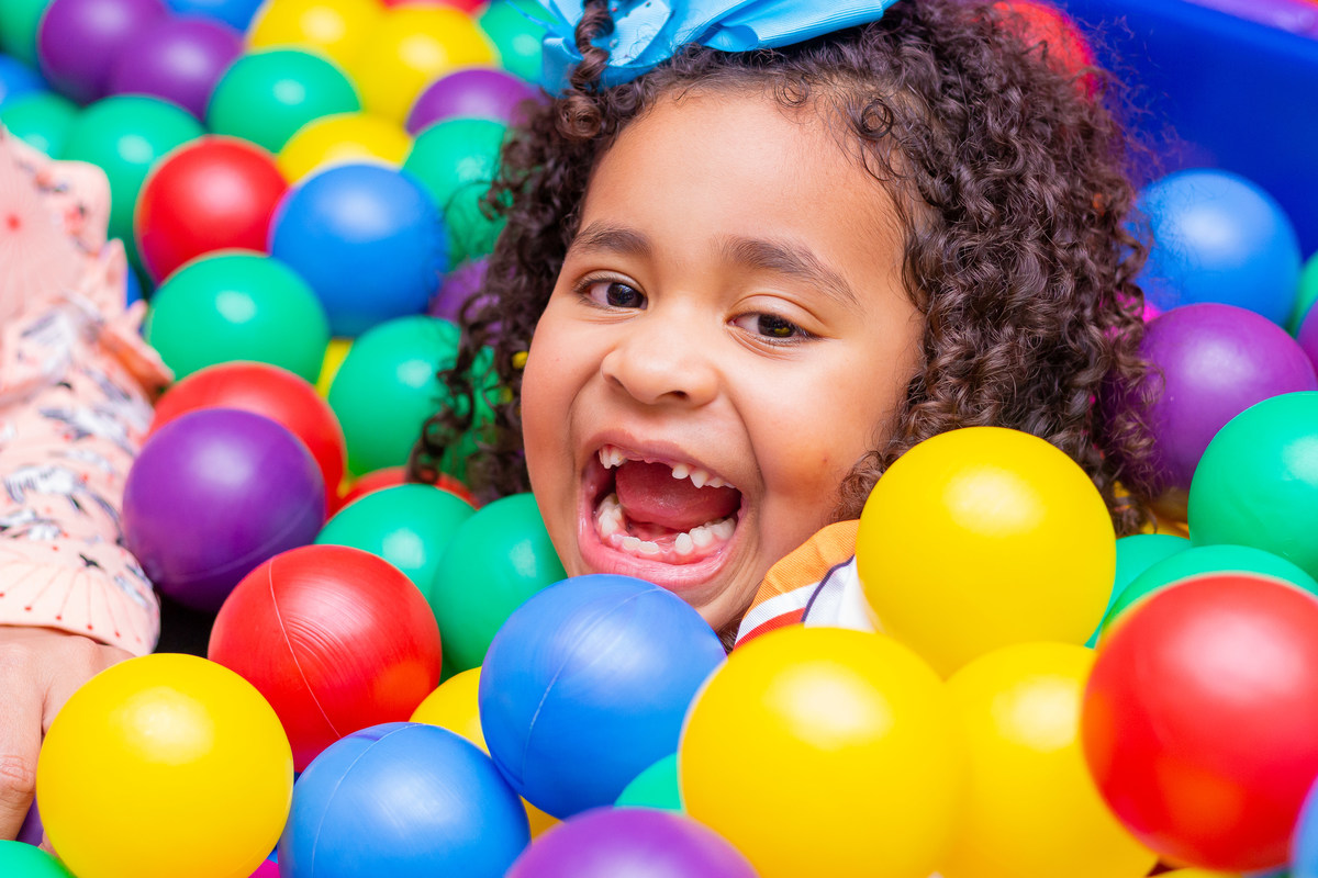 aniversário bauru shopping, decoração fini, decoração arco-iris, aniversariante brincando na piscina de bolinhas