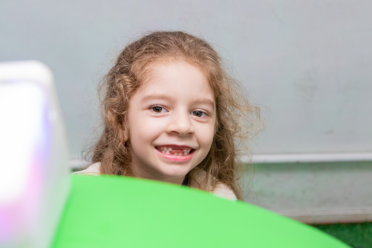 aniversário bauru shopping, decoração fini, decoração arco-iris, convidada sorrindo para a foto