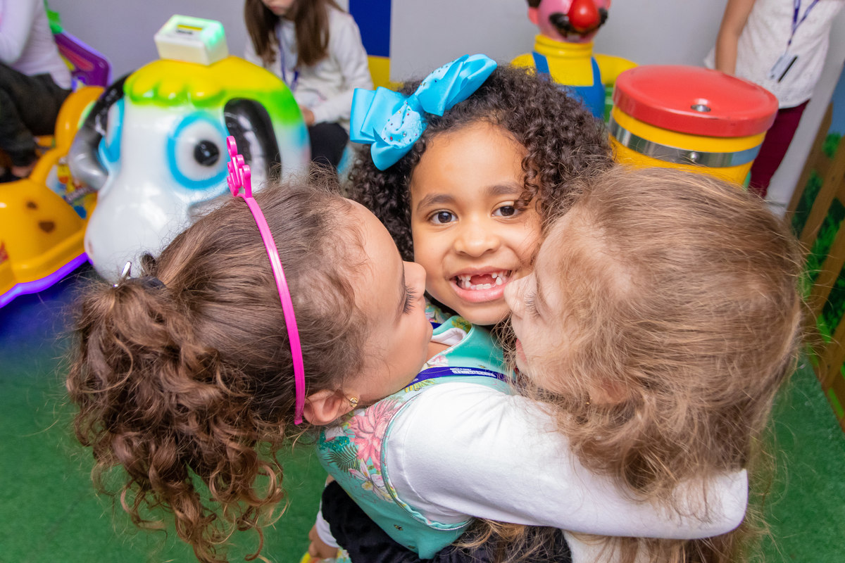 aniversário bauru shopping, decoração fini, decoração arco-iris, aniversariante e amigas se abraçando