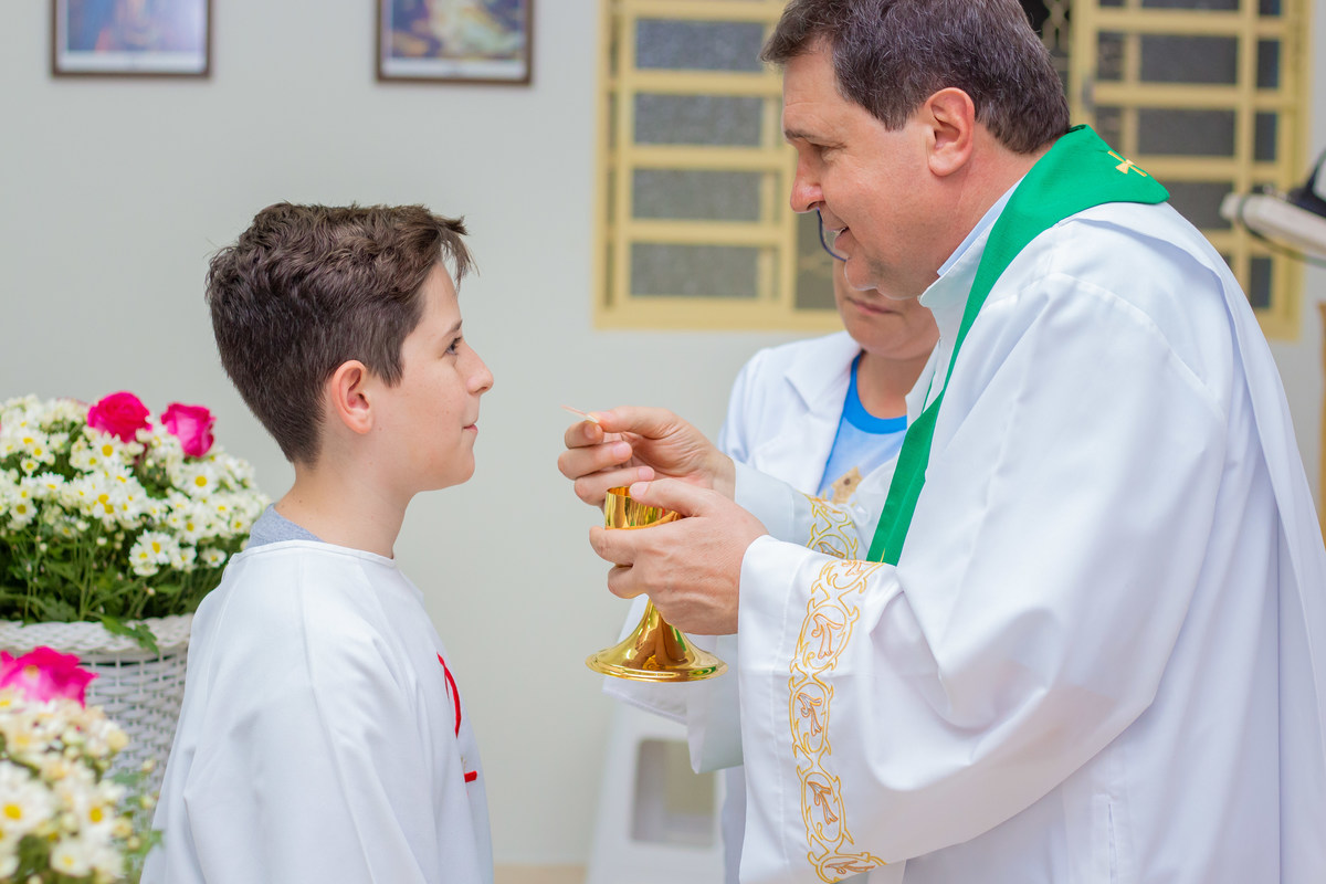 Capela Nossa Senhora das Graças Bauru, primeira eucaristia, criança confirmando o corpo e sangue de cristo, criança recebendo a eucaristia