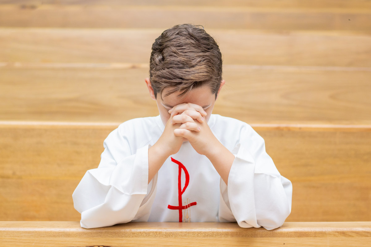 Capela Nossa Senhora das Graças Bauru, primeira eucaristia, menino rezando em sua primeira eucaristia