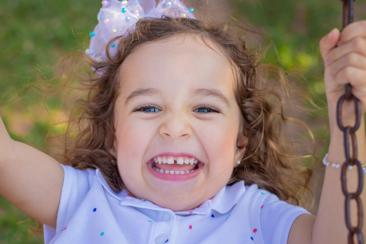 Eco parque de Duartina, ensaio infantil. ensaio em família, ensaio externo infantil, menina brincando no balanço e sorrindo 