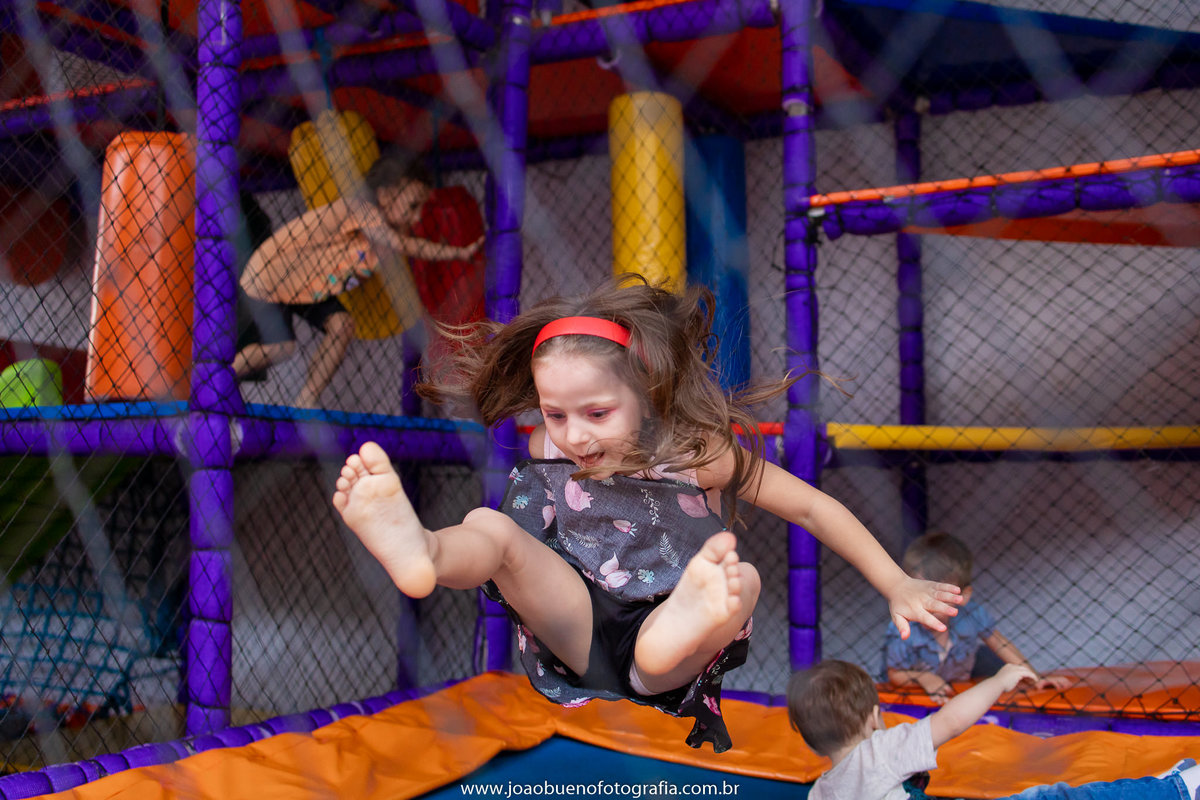 Buffet Zappteen em Bauru, decoração Os descendentes, fotógrafo em Bauru, João Bueno Fotografia, menina brincando na cama elástica
