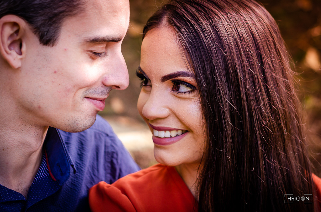 foto bem próxima  dos rostos do casal, os dois de perfil, se olhando e sorrindo