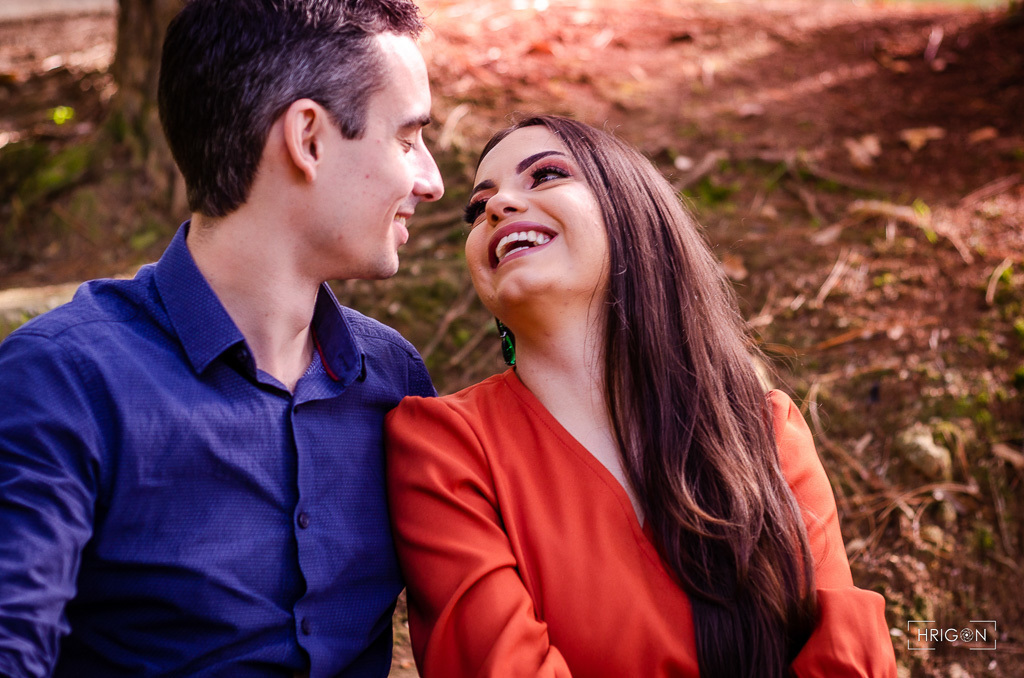 casal sentados na escada se olhando enquanto ela dá uma risada bem espontânea olhando para ele