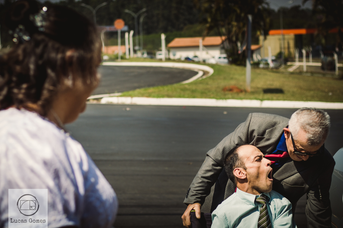 Colocando o noivo na cadeira enquanto sua noiva o olha
