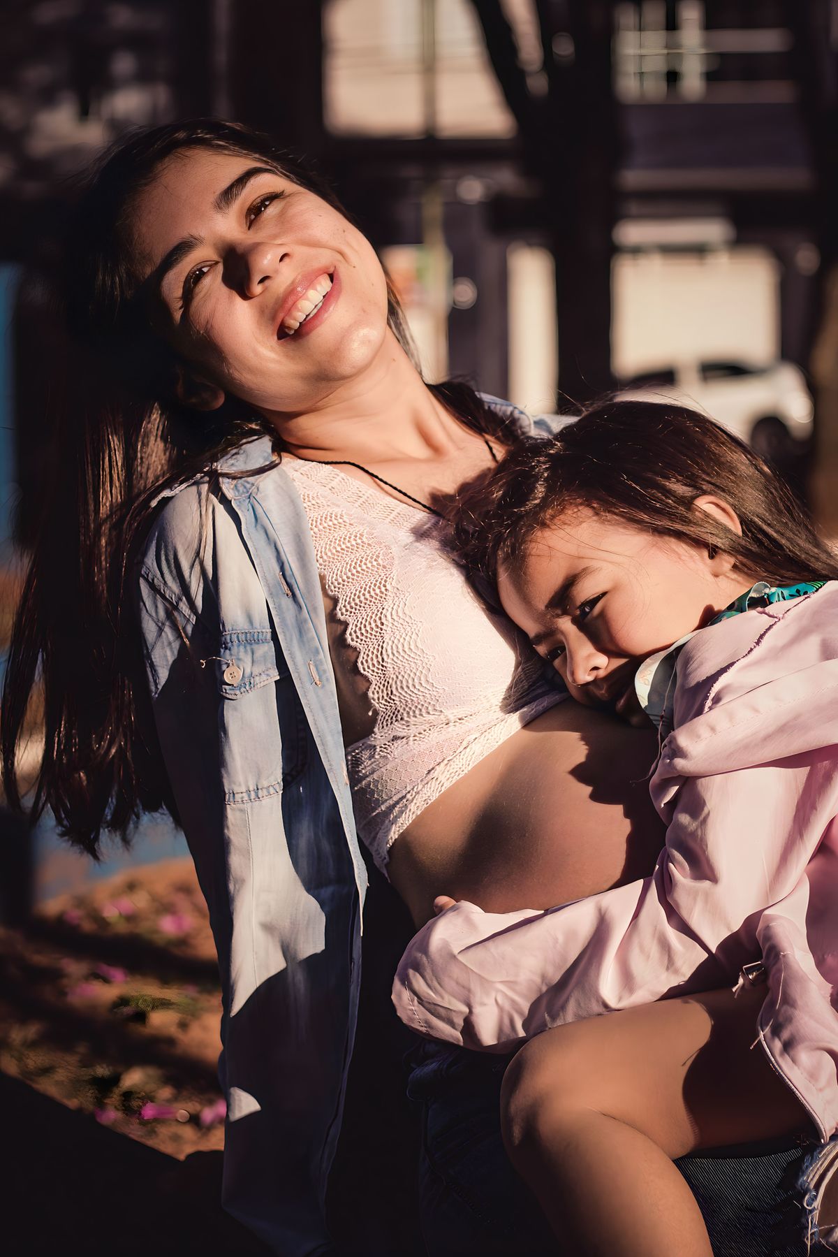fotografia filha da gestante abraçando ela e sorrindo