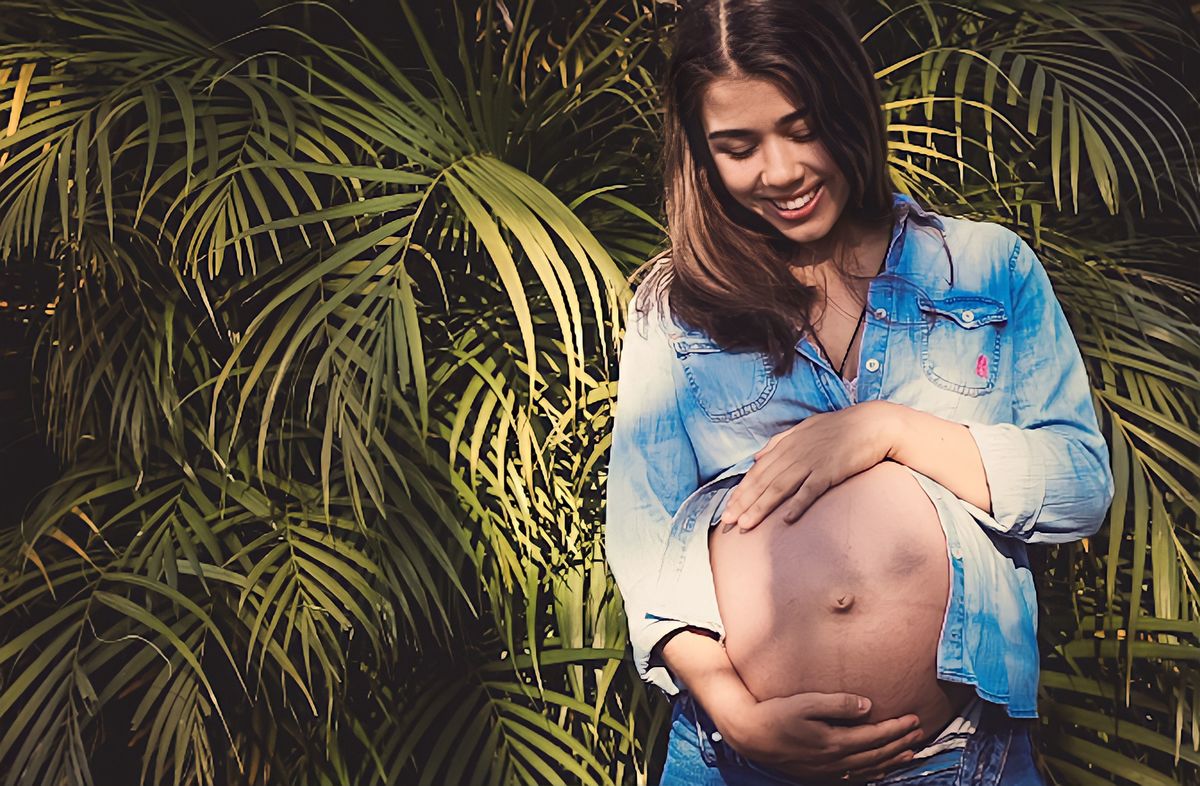 fotografia da gestante sorrindo e abraçando sua  filinha na barriga