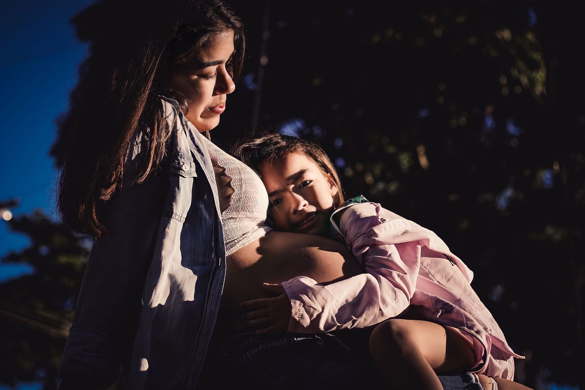 fotografia da filha deitada no colo da mãe gestante