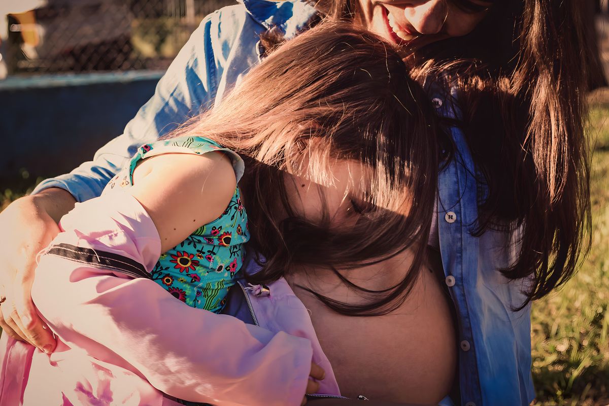 fotografia da filha da gestante escondendo o rosto de tmidez