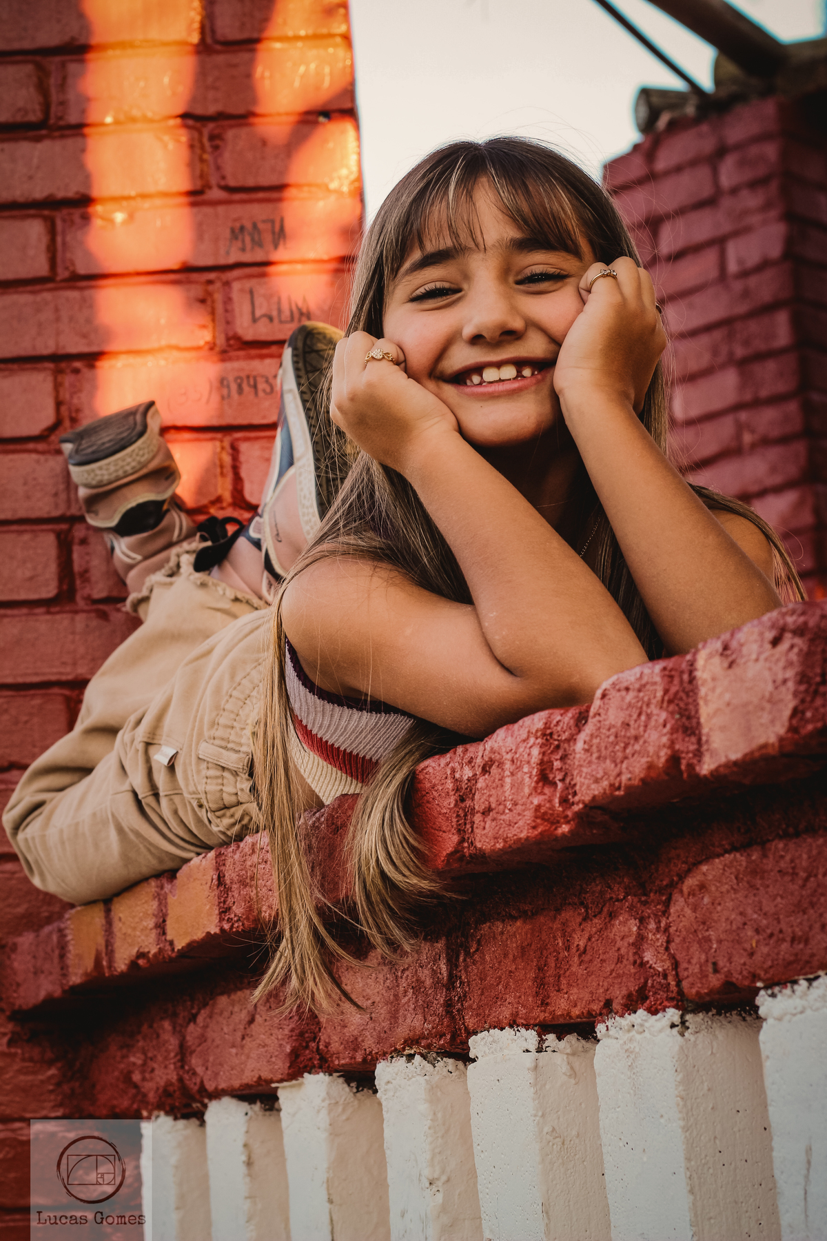 Fotografia de uma menina deitada com a cabeça escorada  nas mãos