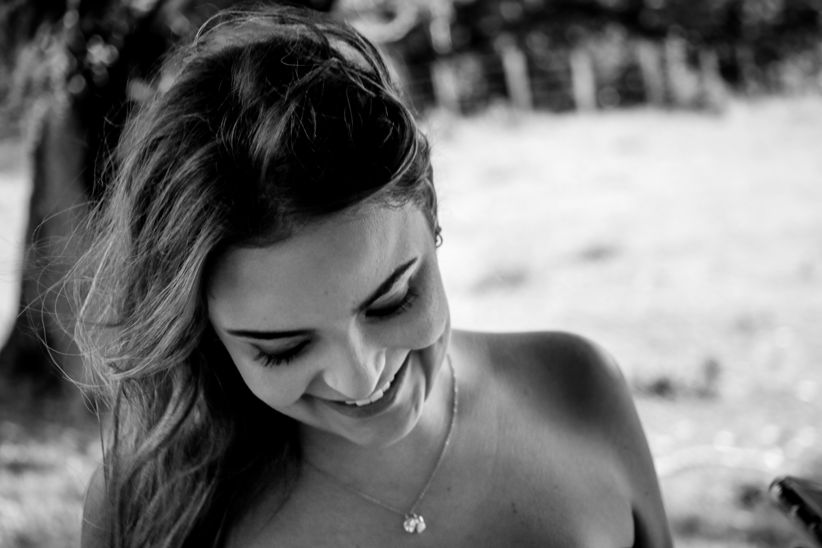  Fotografia de Mulher com a cabeça baixa sorrindo em preto e branco 