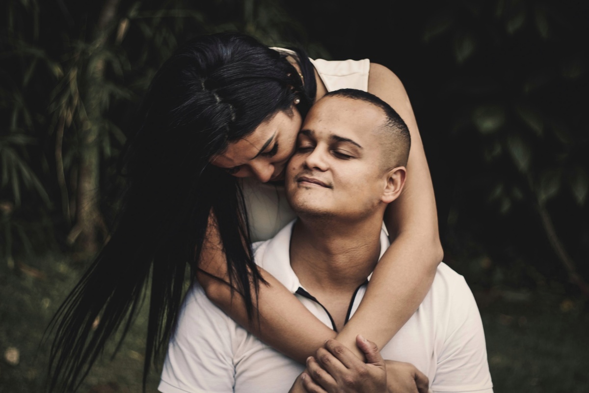 retrato do noivo sendo abraçado pela noiva por trás
