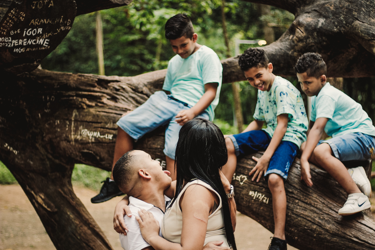 fotografia das crianças na arvore mos trando a lingua pro seu pai e o pai mostrando de volta