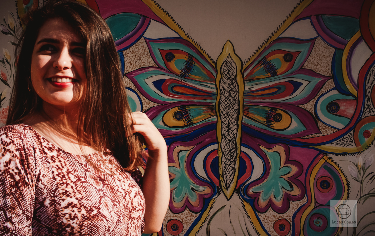 fotografia em aguas de lindoia de mulher com uma borboleta colorida no fundo