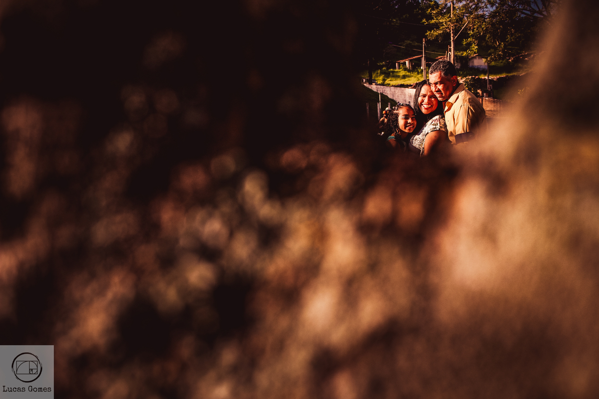 fotografia criativa de familia vista em um buraco de arvore