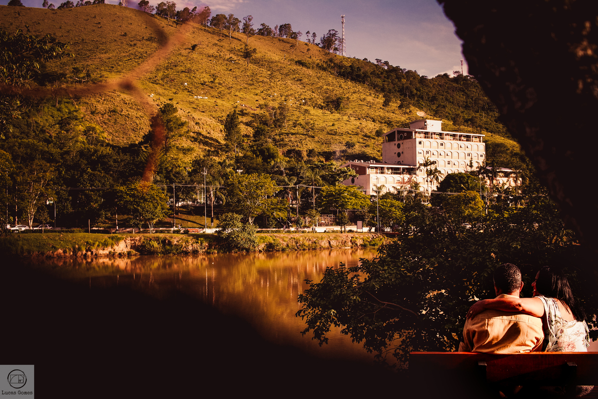 fotografia de mulher e marido sentados em um banco adimirando o lago